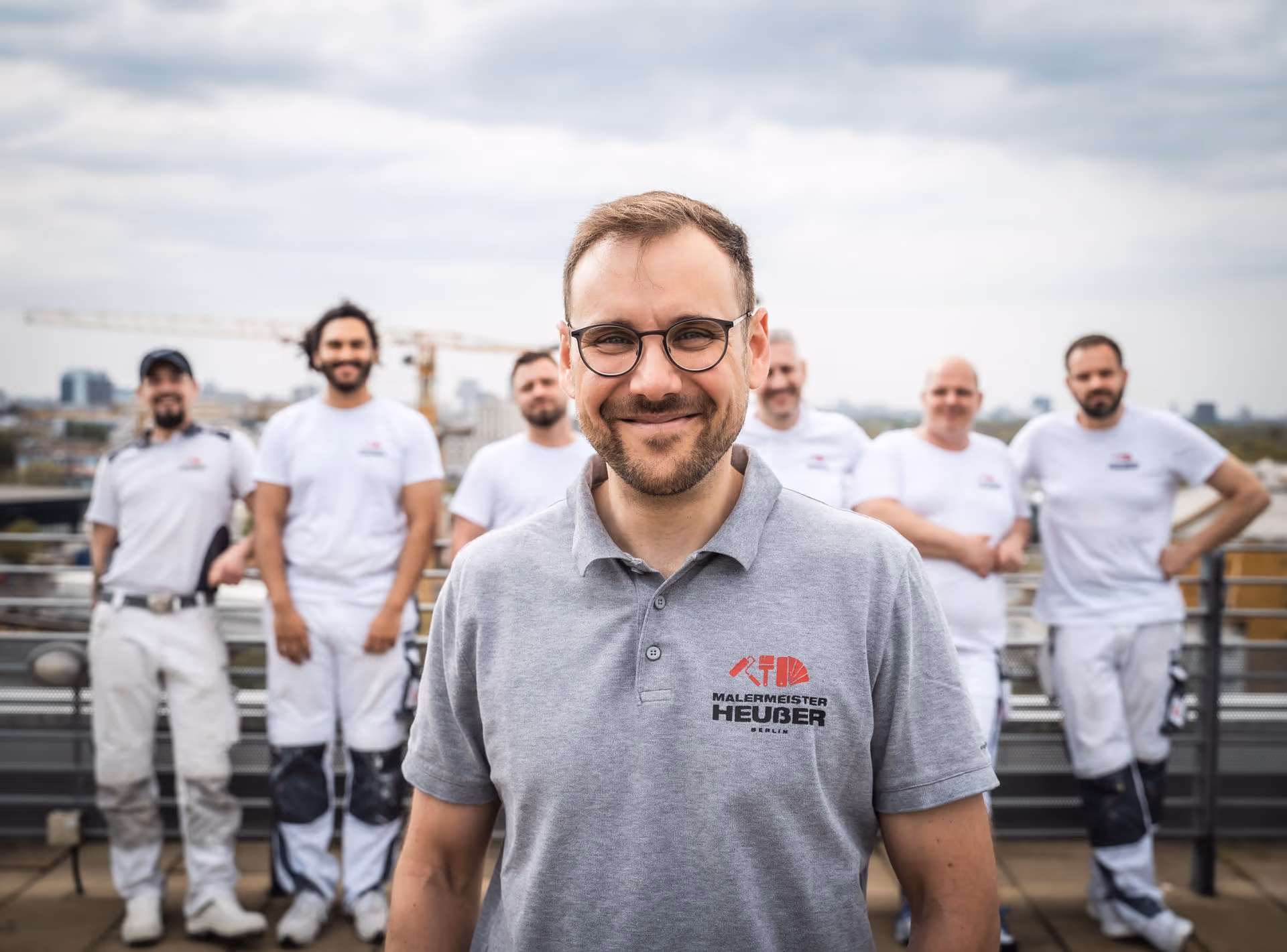 Malermeister Nicolai Heußer mit seinem Team auf einem Dach in Berlin